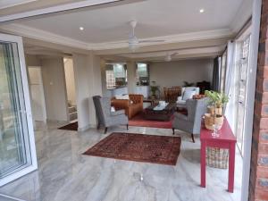 a living room with chairs and a table at Ballito Clarke Bay Beach House - family holiday letting in Ballito