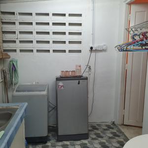 a kitchen with a small refrigerator and a sink at Homestay Cempaka Star in Ipoh +6 photos