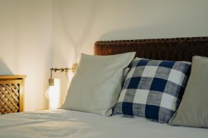 Una cama con almohadas azules y blancas. en Apartamentos Etxetxu Branka eta Ankora, en Getxo