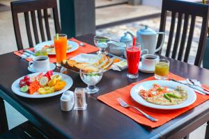 uma mesa com pratos de comida e bebidas em Mimoza Mirissa em Mirissa