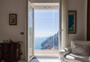 Camera con porta scorrevole in vetro che si apre su un balcone. di B&B Mamma Rosa Positano a Positano