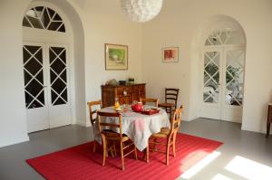 comedor con mesa y alfombra roja en La Lit'Hote, en Mirefleurs