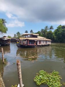 a boat is docked on a river at Johnson's Homestay - Ecohouseboat in Alleppey
