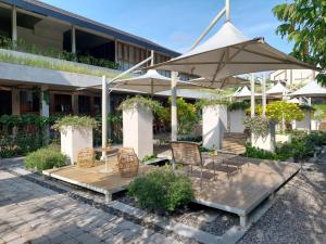 een patio met stoelen en een parasol voor een gebouw bij Ayom Java Village Solo in Solo