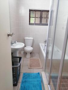 a bathroom with a toilet and a sink and a shower at Eden Wilds Unit 8 in Port Edward