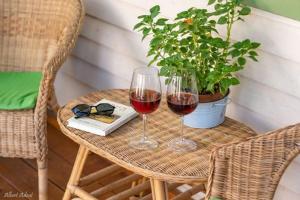 due bicchieri di vino rosso seduti su un tavolo di Anat's Cabin הצימר של ענת a Kefar H̱ananya