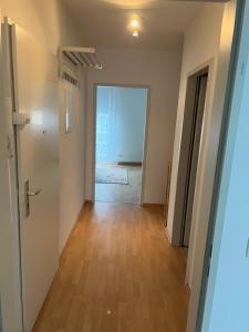 - un couloir d'un appartement avec une porte et du parquet dans l'établissement Deluxe Apartments in Hearth of Downtown, à Düsseldorf