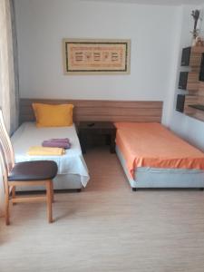 a small room with two beds and a chair at Apartments Victoria in Kranevo