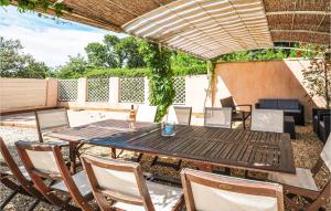 a patio with a wooden table and chairs at Amazing Home In Ste-anastasie-s-issole With Jacuzzi, Wifi And Private Swimming Pool in Sainte-Anastasie-sur-Issole