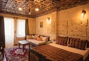 a bedroom with two beds and a couch at Olivia Cave Hotel in Göreme