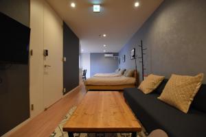 sala de estar con 2 camas y sofá en PrimeRoom別府 朝見, en Beppu