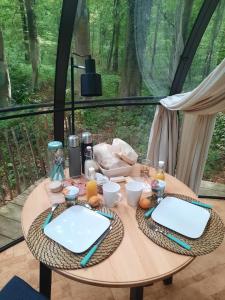 a table with two white plates on top of it at Le Dôme de Namur - Une nuit insolite dans les bois in Champion