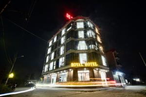 een hotelgebouw met 's nachts een neonbord bij Hotel Royal in Hanoi