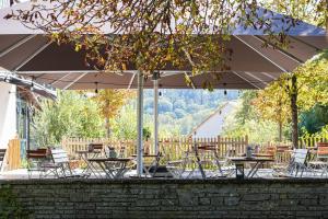 a group of tables and chairs under an umbrella at Hotel Schmiedhubers in Engelsberg