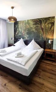 ein großes Bett in einem Zimmer mit einem Gemälde an der Wand in der Unterkunft Hotel Schmiedhubers in Engelsberg