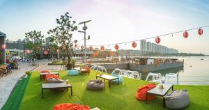 a park with tables and chairs on the grass near the water at ห้องพักรายวัน เมืองทองธานี เรือนศรีตรัง in Ban Bang Phang