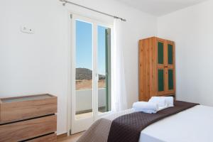 a bedroom with a bed and a large window at Villa Marmara in Cherronisos