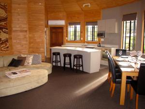 cocina y sala de estar con sofá y mesa en Ngauruhoe Yurt - Ohakune Holiday Home en Ohakune
