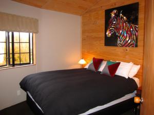 a bedroom with a bed with a zebra picture on the wall at Ngauruhoe Yurt - Ohakune Holiday Home in Ohakune