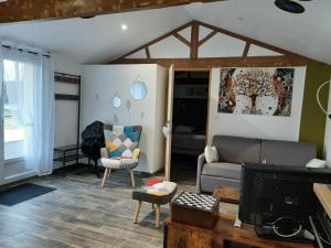 ein Wohnzimmer mit einem Sofa und einem TV in der Unterkunft Le Clos Sainte Lea in Mouilleron-le-Captif
