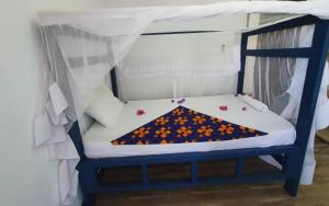 a blue bunk bed with a blanket on it at Ondo House in Nungwi