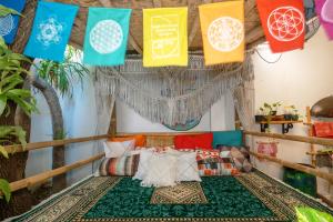 a room with a bed with colorful pillows and flags at Happy Buddha Yogyakarta in Yogyakarta