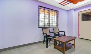 Zimmer mit 2 Stühlen, einem Tisch und einem Fenster in der Unterkunft Itsy By Treebo - 99 Inn Hitech City in Hyderabad
