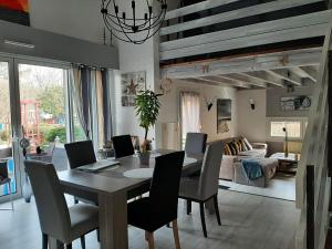 a dining room with a table and chairs and a living room at Le Clos Sainte Lea in Mouilleron-le-Captif