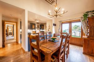 a dining room and kitchen with a wooden table and chairs at Coorie View in Kilmore