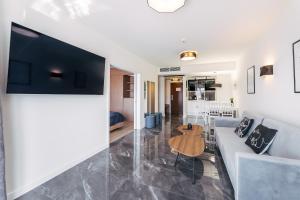 a living room with a couch and a table at Apartament Baltic Plaza 316 in Kołobrzeg