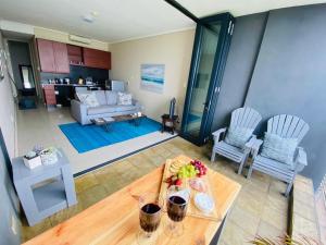 uma sala de estar com uma mesa e um sofá em The Waves, 302 Quayside Point Waterfront em Durban