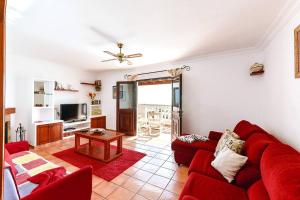 a living room with a red couch and a table at Casa Bellavista in Tías