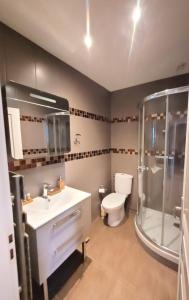 uma casa de banho com um WC, um lavatório e um chuveiro em Hotel Oh Sevres Autrement em Sèvres