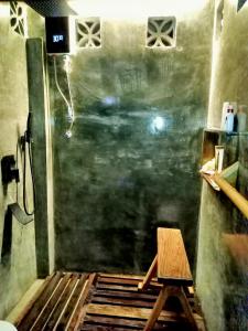 a shower with a wooden stool in a room at shakabrah beach club cottage in General Luna