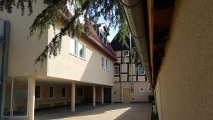 an empty courtyard of a building with a tree at Hotel & Restaurant Hubertus Sehnde in Sehnde
