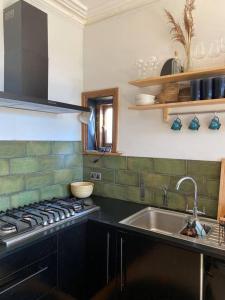 a kitchen with a sink and a stove at Edwardian Villa by the Sea Coastal Walks King Beds in Walton-on-the-Naze