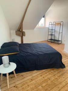 een slaapkamer met een blauw bed en een tafel bij Maison proche Mont Saint Michel in Beauvoir