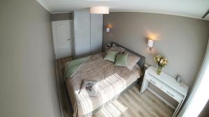a small bedroom with a bed and a table at Spilves 35 in Riga