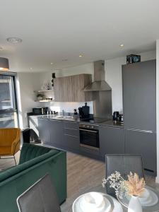 a kitchen with stainless steel appliances and a living room at 2 bedroom with big balcony and gym in Manchester