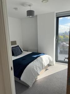 a bedroom with a bed and a large window at 2 bedroom with big balcony and gym in Manchester