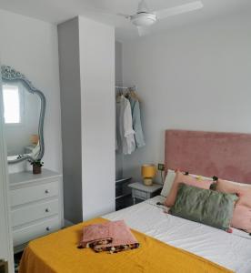 een slaapkamer met een bed met een gele deken erop bij ABA DALÍ in Conil de la Frontera