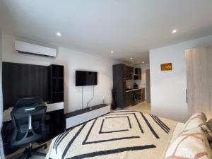 a bedroom with a bed and a desk and a chair at The Lennox Luxury Apartment in Accra