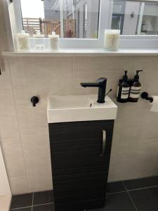 a bathroom with a white sink and a mirror at Beautiful 1-Bed Cabin in Hayling Island in South Hayling