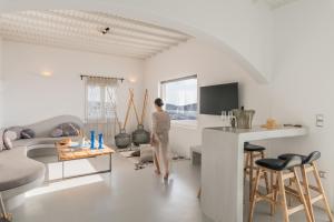 a woman is standing in a living room at Yalos mykonos 3 bedroom Luxury home in Mykonos Town with Sea & Sunset view in Tagou