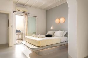 TagouにあるYalos mykonos 3 bedroom Luxury home in Mykonos Town with Sea & Sunset viewの白いベッドルーム(ベッド1台、大きな窓付)