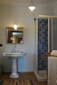 a bathroom with a sink and a shower with a mirror at Casapecchenino in Dogliani