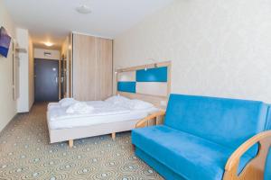 Habitación de hotel con cama y sofá en Imperiall Resort & MediSpa en Ustronie Morskie