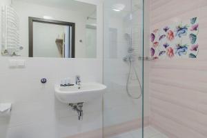 a white bathroom with a sink and a shower at Imperiall Resort & MediSpa in Ustronie Morskie