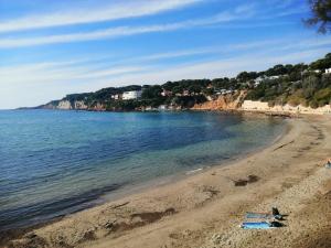una spiaggia con persone sdraiate sulla sabbia e sull'acqua di L'Ecrin d'Azur a Sanary-sur-Mer