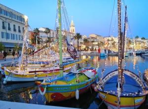 dos barcos están atracados en un puerto con luces navideñas en L'Ecrin d'Azur en Sanary-sur-Mer